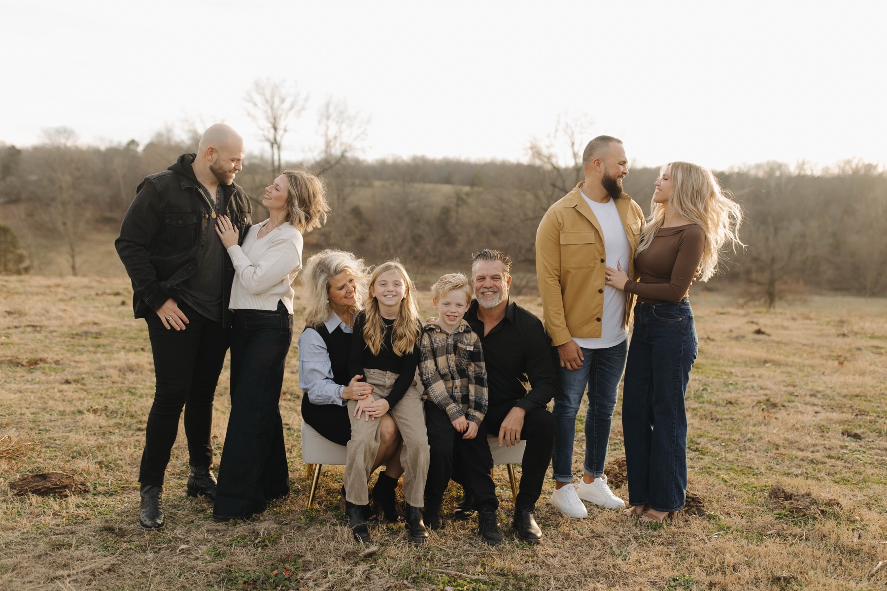 The extended Bilderback family laughing together in the field at golden hour.