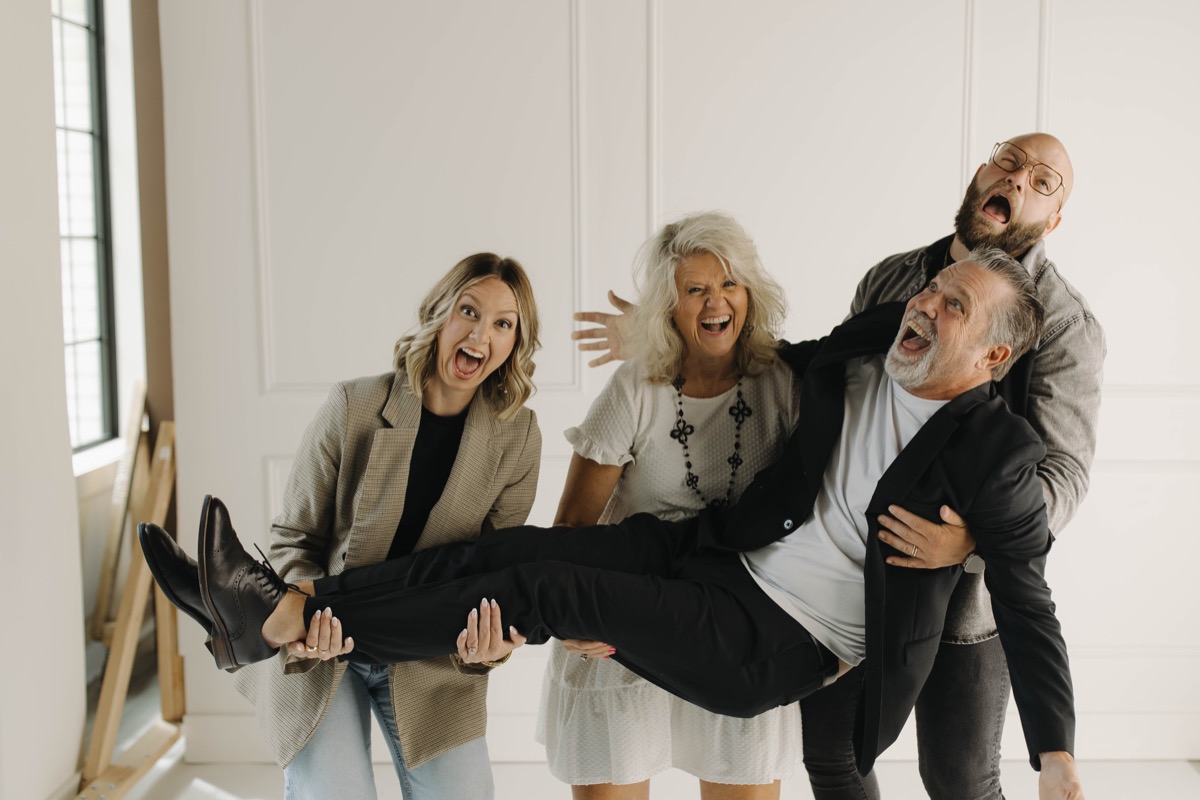 The family laughing hysterically, carrying Euel between them.